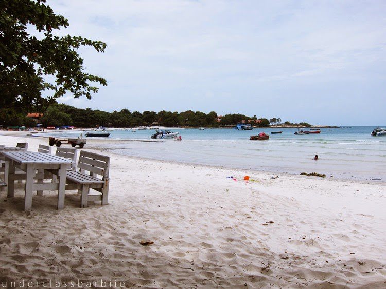 Koh Samet Thailand: 8 Best Relaxing Things to Do 4 Calm afternoon on a white sand beach with scattered trees and distant swimmers at Koh Samet Thailand