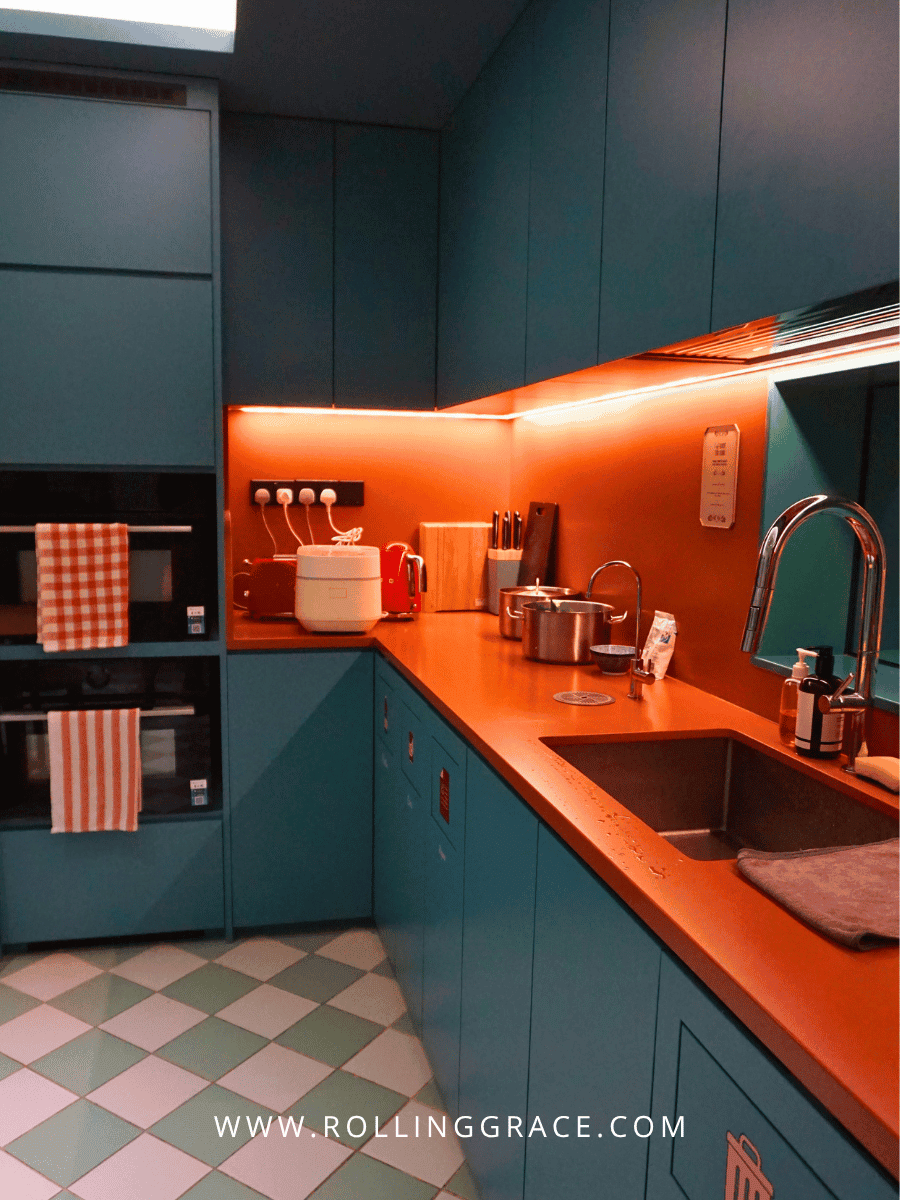 Communal pantry and social kitchen with orange cabinets at lyf Chinatown Singapore