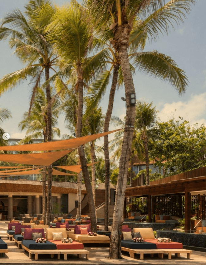 12 Best Shisha in Bali: Hookah in Canggu, Seminyak & Ubud 6 Tropical dusk exterior of Alunê at W Bali Seminyak with palm trees and warm lighting, a new entry for best shisha in Bali by Rolling Grace