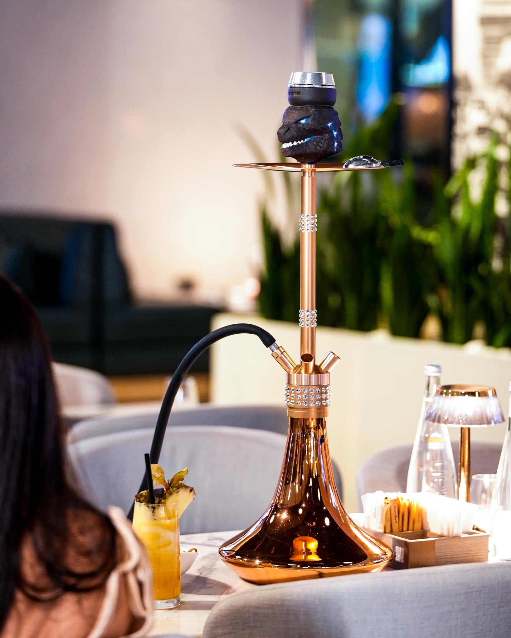 Café De Paris Business Bay shisha lounge with traditional hookah pipe and cocktails on the table