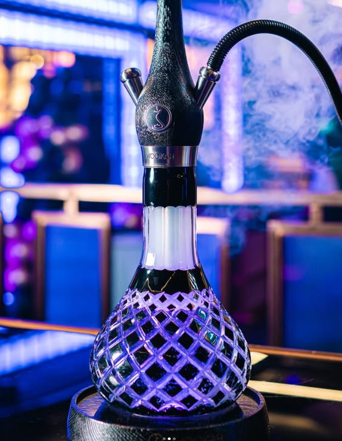 Noya London purple glass hookah pipe in a moody lounge setting on West Green Road