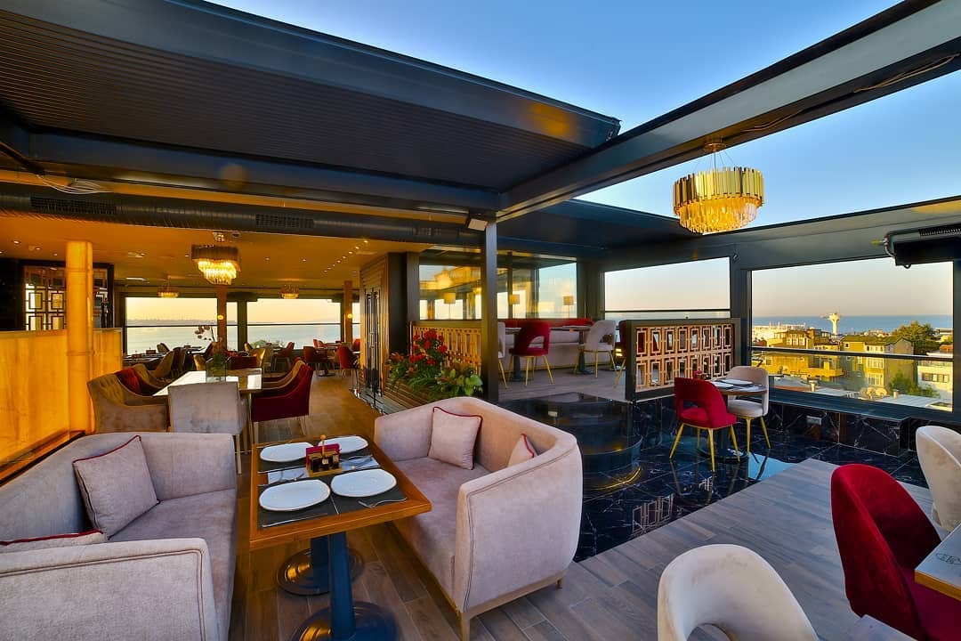 Best Shisha in Istanbul, Turkey: 10 Amazing Nargile to Try 7 Rooftop dining setup with blue-lit tables and sea views at Queb Rooftop Restaurant in Istanbul