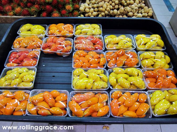 Trays of wild red and orange durian Borneo fruits for sale at a Sabah tamu market stall