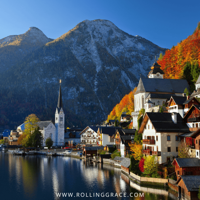 Alpine lakeside town with mountains and church spires in Austria one of the safest countries for solo female travel