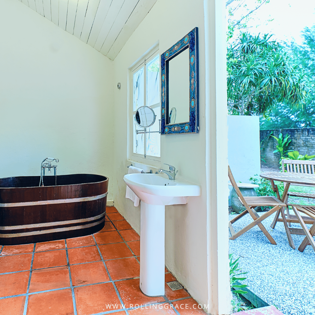 Wooden bathtub and basin opening onto a gravel yard in an Estate House bathroom, Temple Tree Resort Langkawi