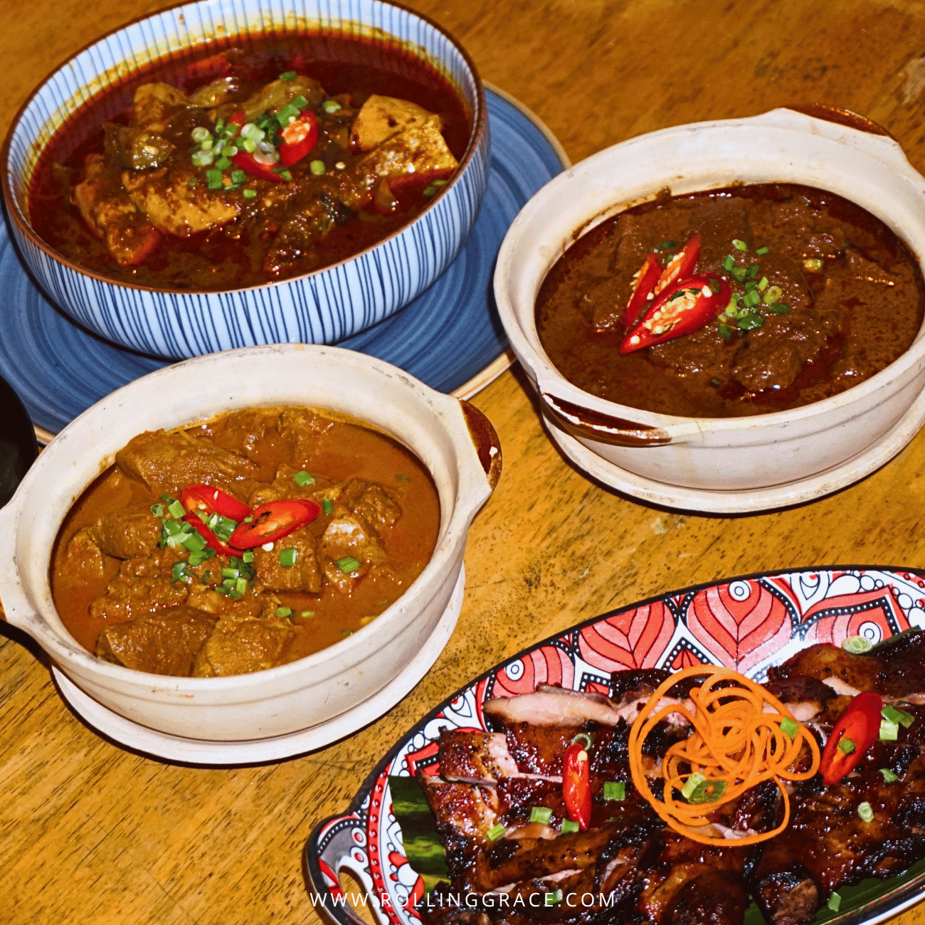 Bowls of rich red curries garnished with chilli on the Paloh After Dark table at Temple Tree Resort Langkawi