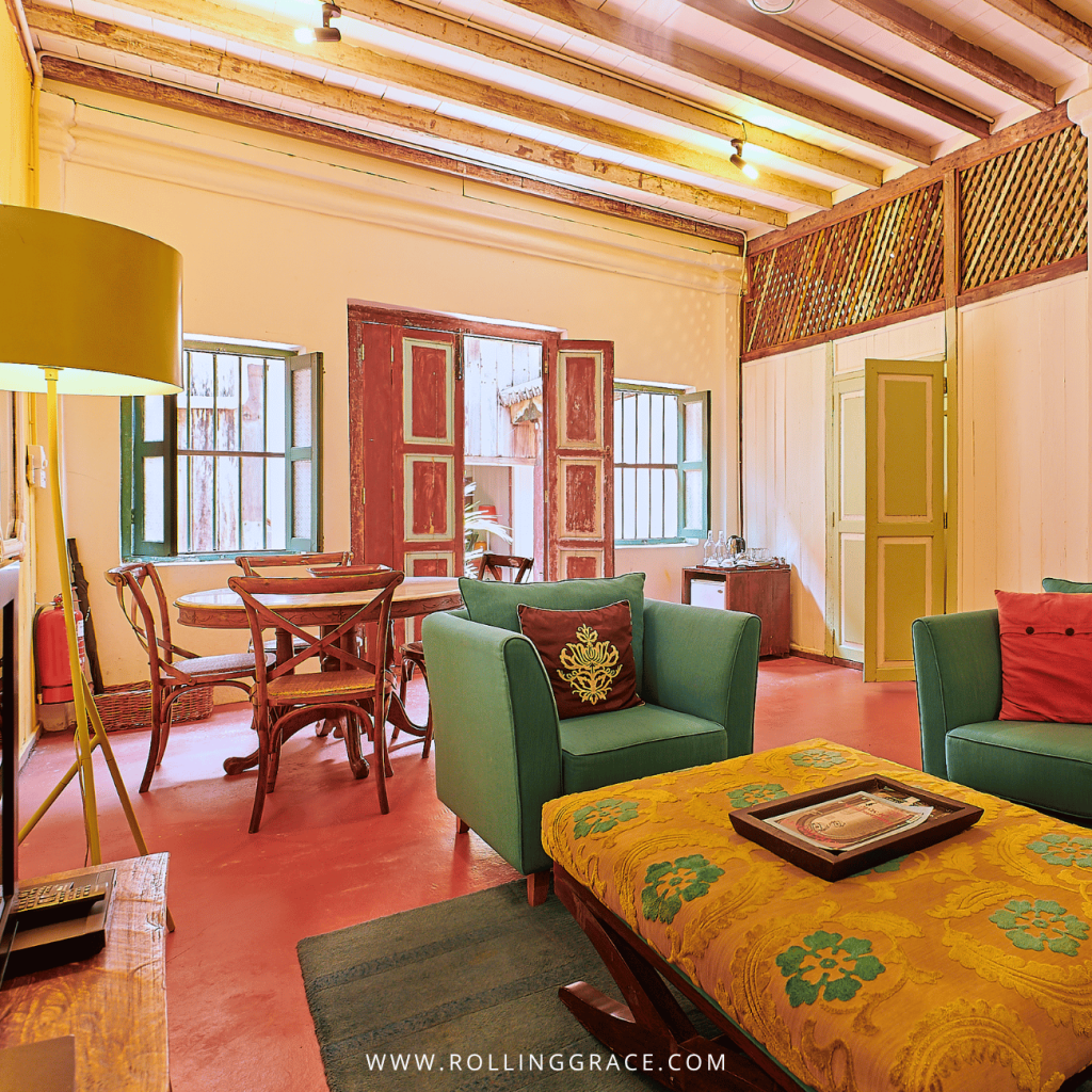 Plantation House suite lounge with green armchairs and a patterned ottoman at Temple Tree Resort Langkawi