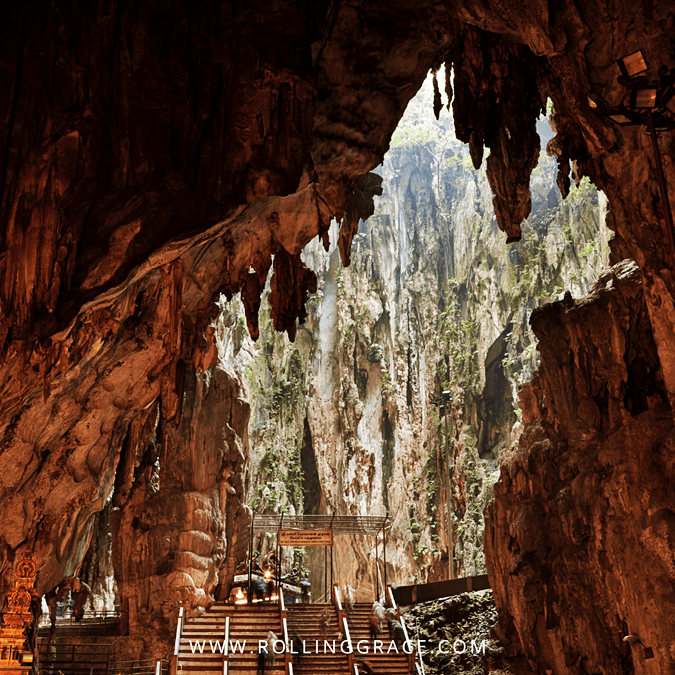 View from inside a limestone cave at Batu Caves, Gombak, looking out through a wide opening to forested cliffs