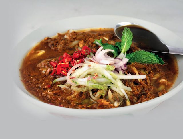 Bowl of Penang asam laksa topped with mint, onion, cucumber and chilli at Restoran Angcle Peoh, Bukit Tinggi Klang