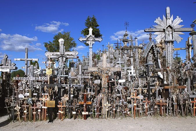 Hill of Crosses: 7 Must-See Sights and Incredible History 6 Hill of Crosses near Šiauliai, Lithuania, with paths through the crosses and flat green farmland stretching to the horizon