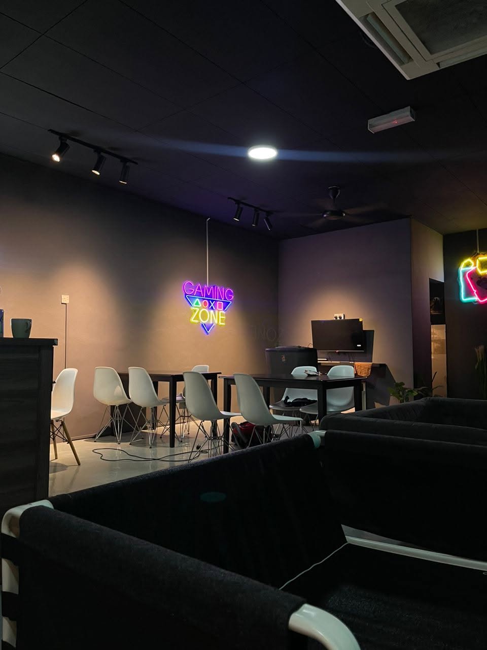 Low-lit lounge with dark sofas and neon signs at IIC Shisha, Mount Austin, Johor Bahru