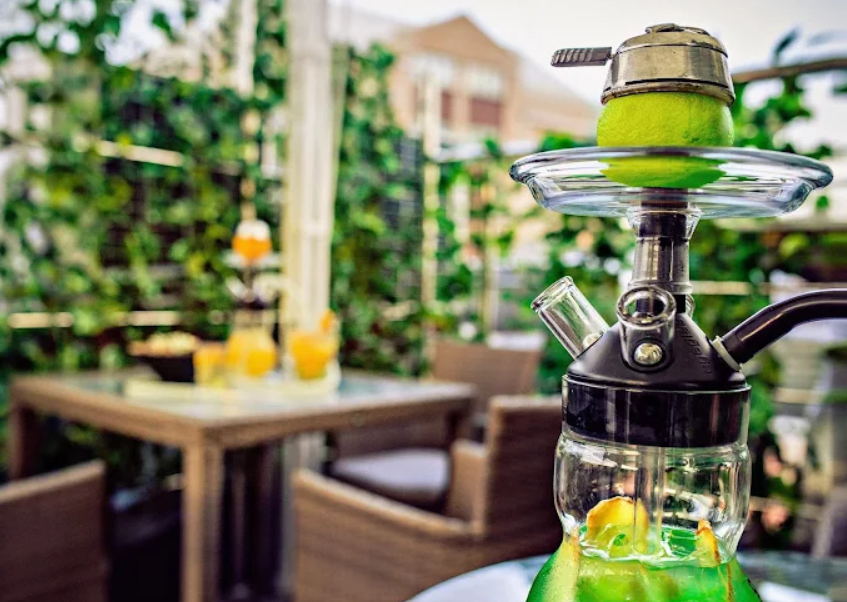 Hookah with a green fruit bowl on the leafy summer terrace at Project 6/2, Old Arbat, shisha in Moscow