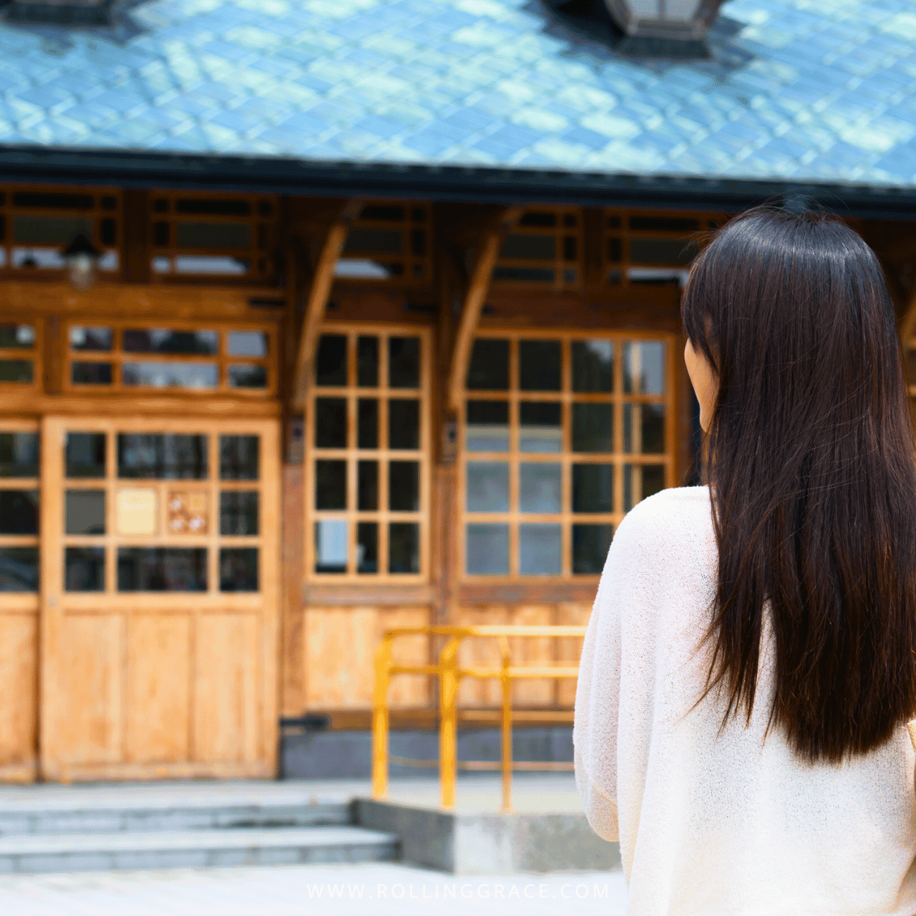 14 Things to Do in Beitou, Taipei: Best Hot Springs & Parks 4 Woman with long dark hair facing the wooden facade of Xinbeitou Historic Station in Beitou, Taipei