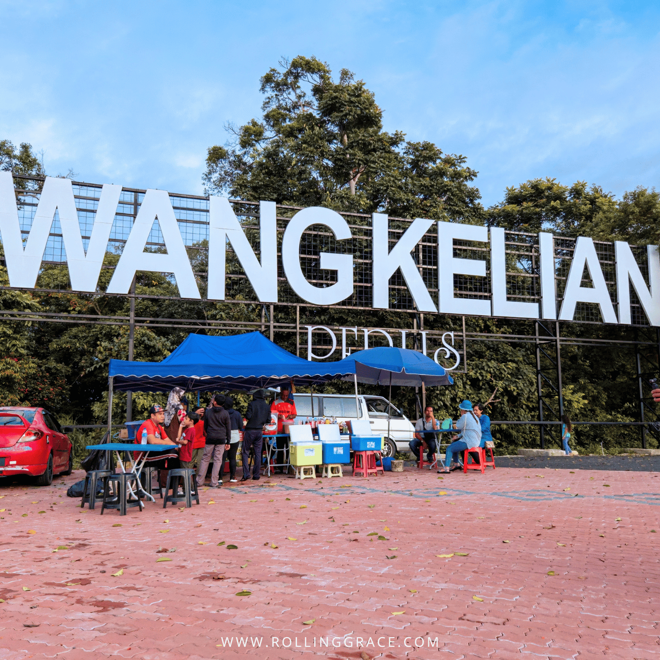 Giant Wang Kelian Perlis letters on a hillside above market stalls and parked cars, a stop on things to do in Perlis